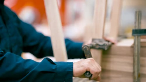 Carpenter Tightening Wood Clamp on Furniture