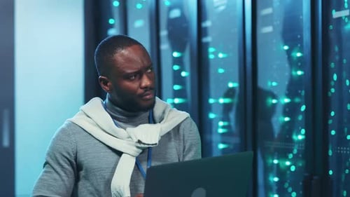 Man Working in Futuristic Data Center with Laptop