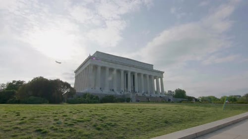 A pushing shot into the Lincoln Memorial on a sunny spring day with a plane flying overhead.