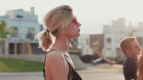 A Woman in a Black Dress and a Man in a Shirt Engage in a Vibrant City