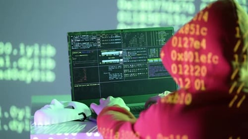 Programmeur masqué travaillant sur un ordinateur portable avec code hexadécimal et fenêtres de terminal sous projection de lumière verte