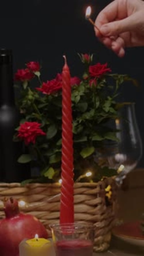 Vertical Video Hand Lights Candle on Festive Table for Valentine's Day