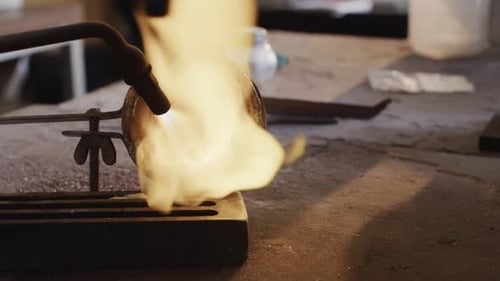 Close up of melting metal with blowtorch in workshop in slow motion