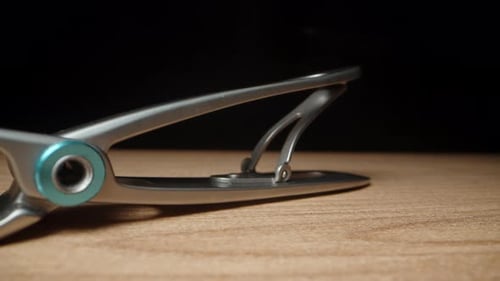 fingernail clipper on a black background. Dolly slider, extreme close-up.
