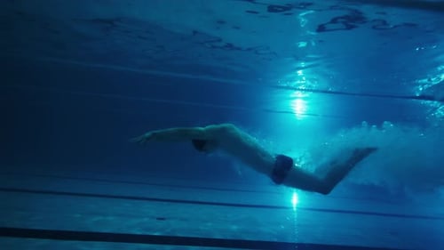 Professionelle Schwimmer trainiert im Pool Unterwasserblick Männlicher Profischwimmer taucht und schwimmt in der