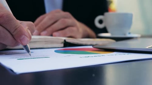 Person Taking Notes During Business Meeting