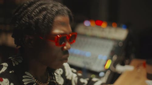 Black Sound Engineer Using Audio Mixer and Vibing to Beat in Recording Studio