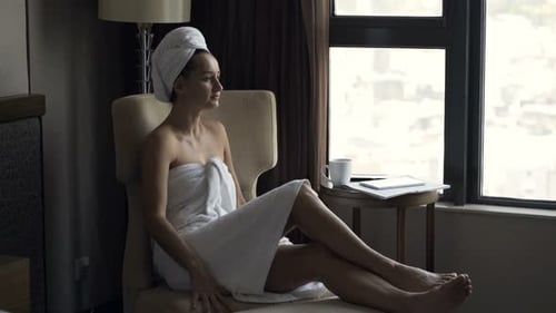 Woman Wrapped in Towel Standing Near Window