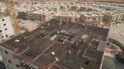 Equipo de trabajadores de la construcción trabajando en la parte superior del edificio.
