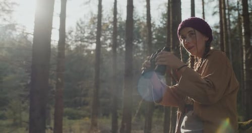 Young Woman Looks Through Binoculars in Forest