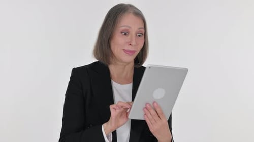 Excited Mature Woman Using Tablet at Home