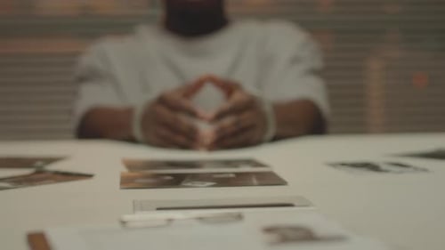 Suspect in Handcuffs at Interrogation Table