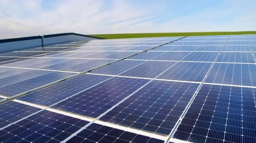Close view of multiple solar panels on the roof of a manufacturing building in nature. Ecology thema