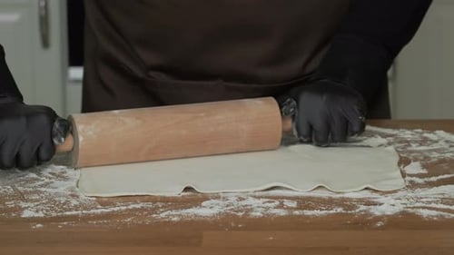Rolling Dough with Rolling Pin in a Kitchen