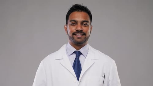 Concepto de medicina, profesión y atención médica: médico o científico indio sonriente