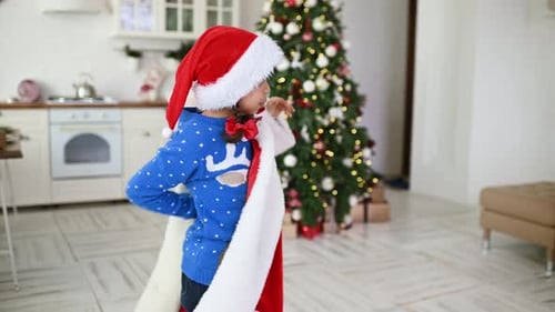 Happy Child Modeling a Santa Suit at Christmas