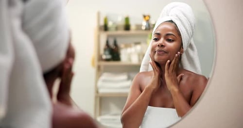 Woman Applies Lotion to Face in Bright Bathroom