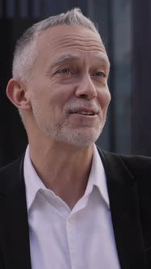 Senior Business Man Standing Gathered Conversing Quietly Outside Office Building