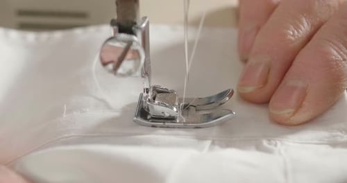 Close Up of Sewing Machine Needle Stitching Fabric