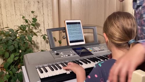 Child Learning Piano with Digital Tablet