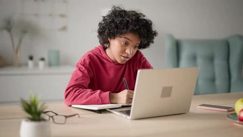 Young Adult Studying at Desk with Laptop