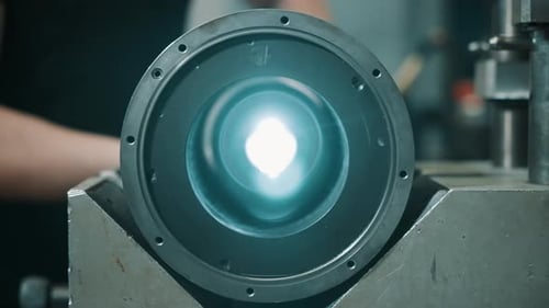 Nahaufnahme eines zylindrischen Metallbauteils, das in eine Bearbeitungsvorrichtung mit kreisförmiger Bohrung eingespannt ist, und