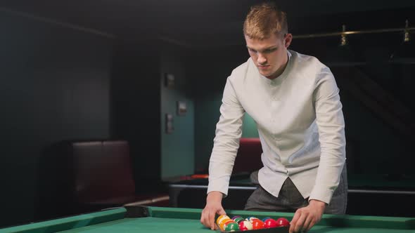 Young Man Arranging Billiard Balls in Triangle Formation on Green Pool ...