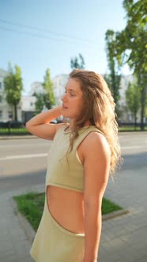 With a Sporty Attitude and Curly Locks a Young Girl Explores the City's Streets During Summer