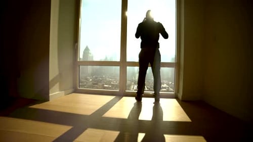 Young Successful Man Living in High Rise City Apartment With Skyline View