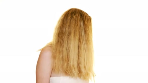 Beautiful red haired young girl turning and flicking her hair about on a seamless white studio backg