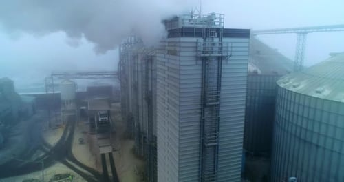 Aerial View of Silos and Industrial Buildings with Smoke