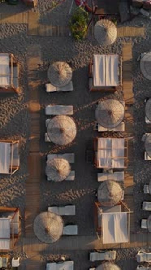 Drone Rising Above Empty Beach Sunbeds and Umbrellas at Sunrise