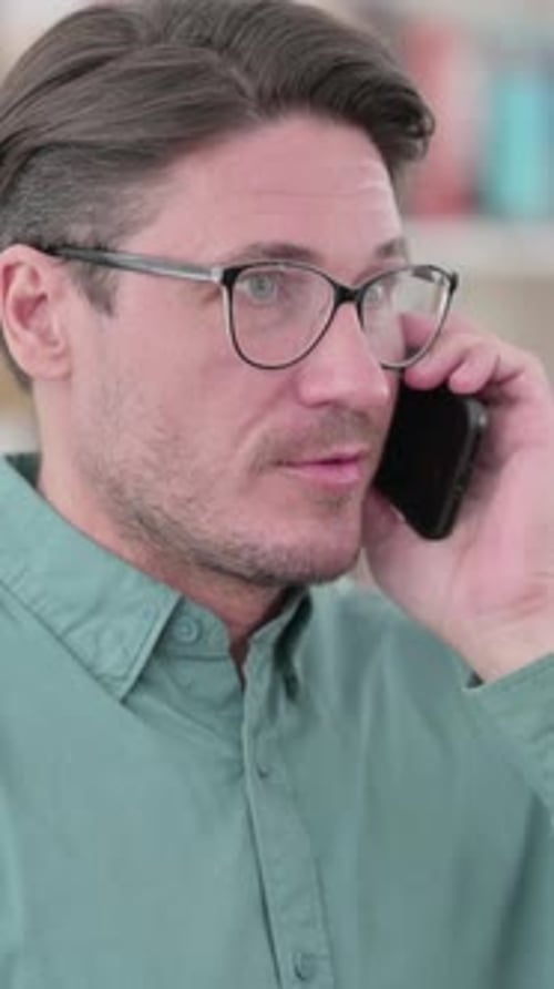 Man in Glasses Having Phone Conversation