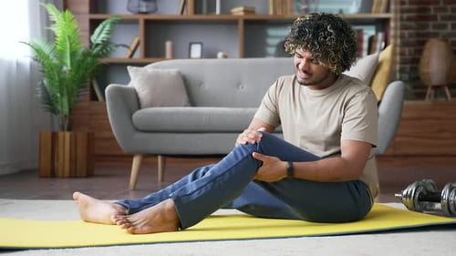 Man Experiences Knee Pain During Home Workout