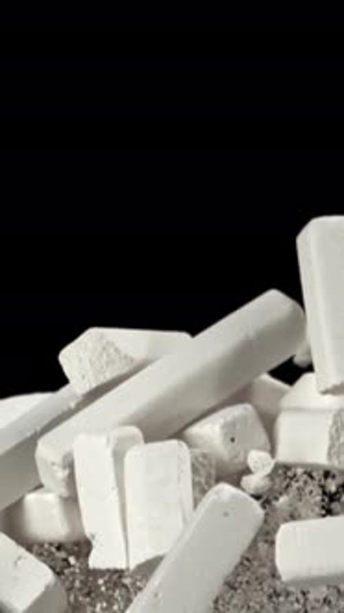 School Chalk Flies Up and Falls Down on a Black Background Filmed on a Highspeed Camera at 1000 Fps