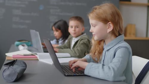 Children Using Laptops at Desks in Classroom