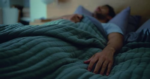 Man Sleeping Peacefully in Cozy Bed at Night