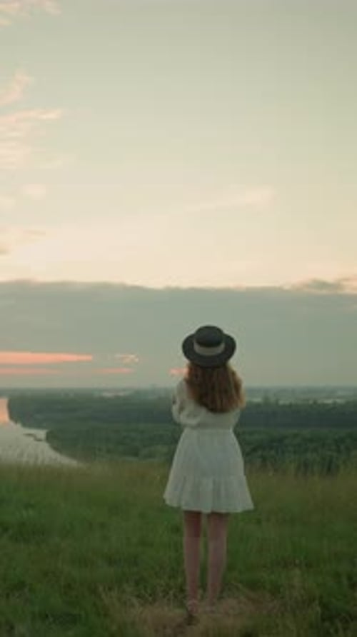 Thoughtful Woman in White Dress Gazing Over Lake at Sunset