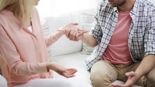 Frustrated couple having serious discussion at home