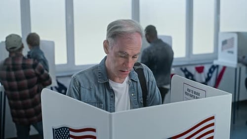 Mature Man Comes to Vote in Booth in Polling Station Office