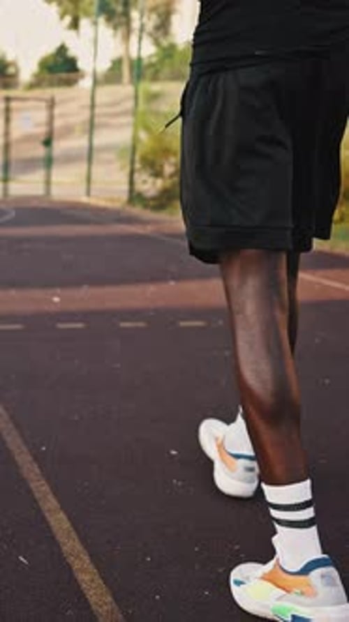 Male Athlete Trains on the Basketball Court and Throws the Ball Into the Basket Rear View of a