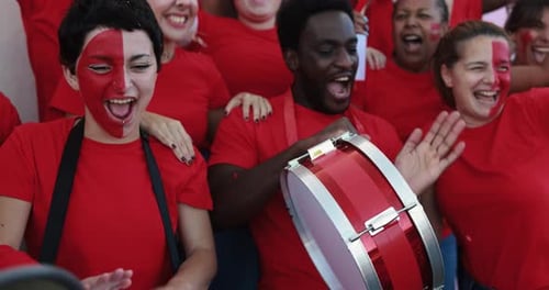 Red sport fans celebrating victory at football world cup match in qatar stadium
