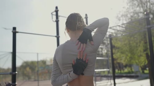 Woman Stretching in City Park at Outdoor Gym