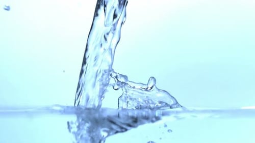 Water Pouring into Clear Water with Splash and Bubbles
