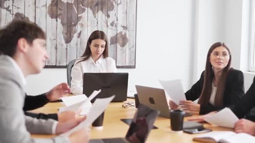 young people in business suits sitting at office at table and discussing
