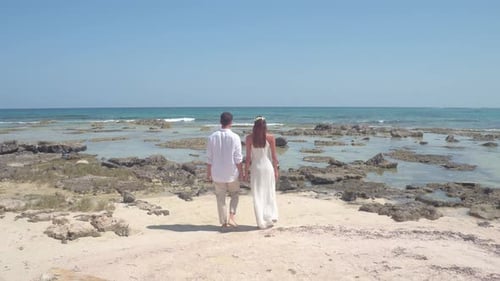 Young Married Couple Walks Tropical Beach After Wedding, Aerial Drone Aerial