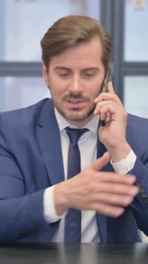 Professional Man Talking on Mobile Phone in Office