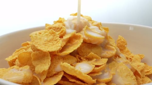 Milk Being Poured on Corn Flakes in Bowl