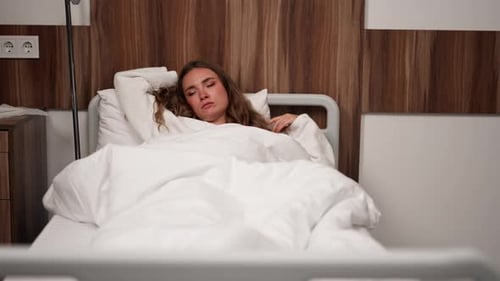 in Modern Clinic in a Bright VIP Room Lies Young Girl in a White Coat with a Cold Medical Care