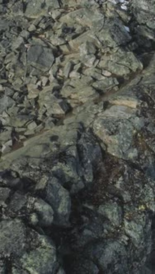 Hiker Man is Hiking and Ascending in Snowy Mountains of Norway Using Walking Poles Aerial View